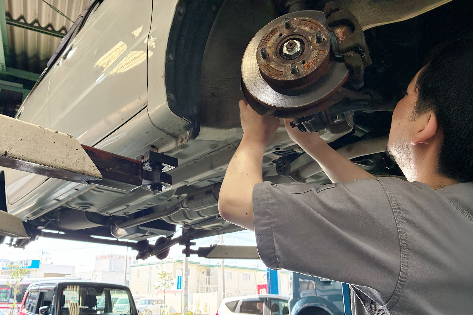 車の下回りを点検する整備士の様子